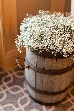 a wooden barrel filled with baby's breath flowers