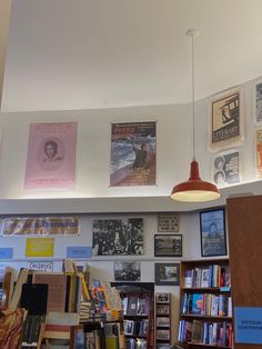 there are many books on the shelves in this room and one light is hanging from the ceiling