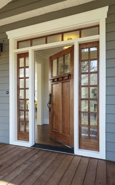 the front door is open and there are two doors on each side of the house