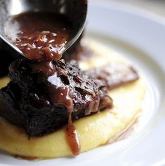 a plate with some food on it and a spoon sticking out of the meat sauce