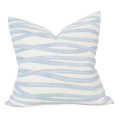 a blue and white pillow with wavy lines on the front, sitting on a white surface