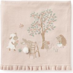 a pink blanket with animals and a tree on the front, along with a ladder