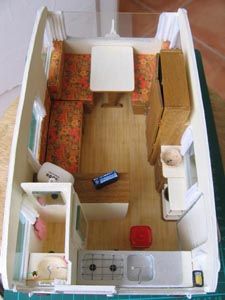 an overhead view of a dollhouse with furniture and kitchen in the living room area