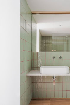 a white sink sitting under a mirror next to a wall mounted faucet in a bathroom