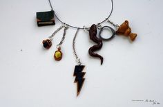 a necklace with various items hanging from it's sides on a white table top