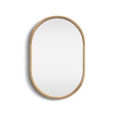 an oval wooden mirror hanging on the wall, with a white back ground and light wood frame