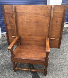 an old wooden chair sitting in front of a blue garage door