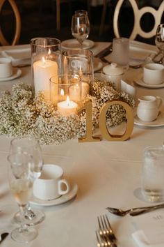 the table is set with flowers and candles