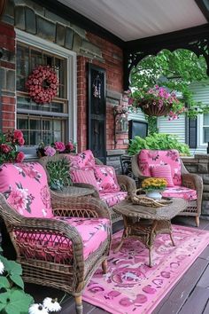 the porch is decorated with wicker furniture and pink cushions, along with potted plants