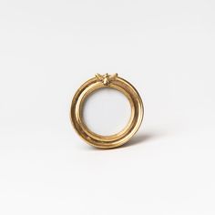 a gold ring with a bow on the top is shown in front of a white background