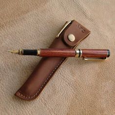 a pen with a leather case sitting on top of it