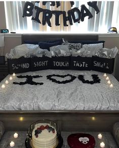 a birthday bed with candles on it and a cake in the foreground that says,'i love you sound sight touch taste smile '