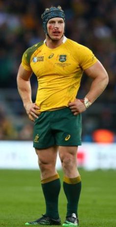 a rugby player is standing on the field with his hands on his hips and looking at the camera