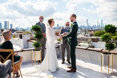 a bride and groom are getting married on top of a building