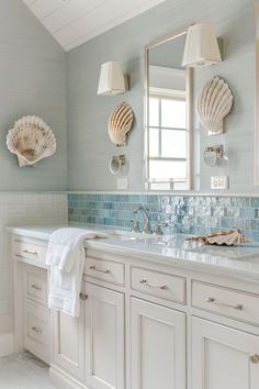 a white bathroom with two sinks and large mirrors on the wall next to each other