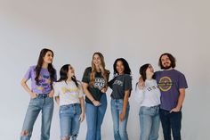 a group of young people standing next to each other in front of a white wall