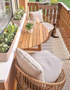 a balcony with wicker furniture and flowers on the table, along with two chairs