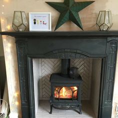 a fireplace with a wood burning stove in the middle and lights around it on either side