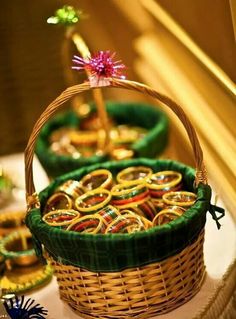 two baskets filled with gold and green rings sitting on top of a table next to other items