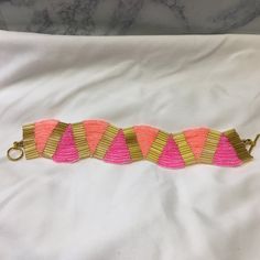 a pink and gold bracelet is laying on a white sheet