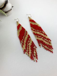 "Red and gold boho seed bead earrings, beaded earrings, fringe abstract seed bead earrings Length 5\" including ear wire Width 1\" Made with best quality Japanese seed beads, and 24k gold dipped seed beads Lightweight and unique extravagant style - designed and made by Luba Ro Colors used - 24k gold, shimmering gold and red Select closure earwires leverbacks clip-ons for non pierced ears" Red Gold Beaded Drop Earrings, Christmas Gold Beaded Earrings, Gold Beaded Earrings With Dangling Beads For Festive Occasions, Handmade Gold Beaded Earrings For Christmas, Festive Gold Beaded Earrings With Round Beads, Red Bohemian Earrings For Christmas, Gold Festive Earrings With Tiny Beads, Festive Gold Beaded Dangling Earrings, Festive Gold Earrings With Tiny Beads