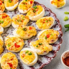 deviled eggs on a plate with red pepper and seasoning