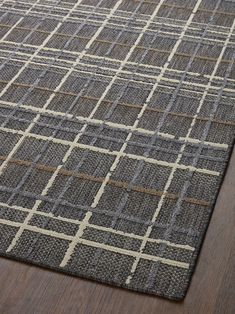 a brown and white rug on top of a wooden floor