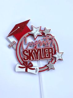 a red and white cake topper with a graduation cap on it