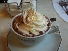 a cup filled with whipped cream on top of a saucer