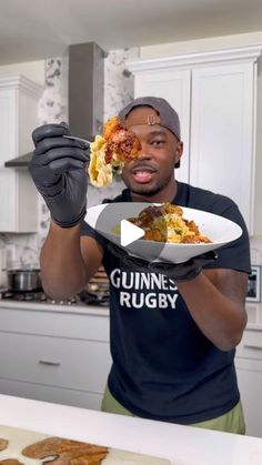 a man holding a plate with food on it in his hands and pointing to the camera