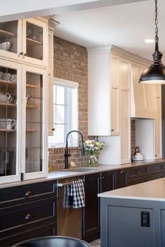 a kitchen with white cabinets and black appliances