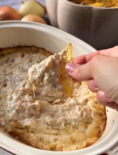 a person dipping some food into a bowl