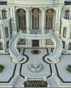 an aerial view of a large white building with stairs leading up to the second floor