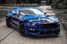 a blue sports car parked on the side of a road