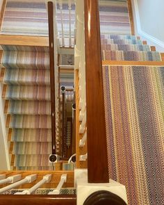 the stairs are lined with multicolored carpet and wooden handrails that lead up to the second floor