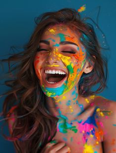 a woman with colorful paint all over her face and body, smiling at the camera