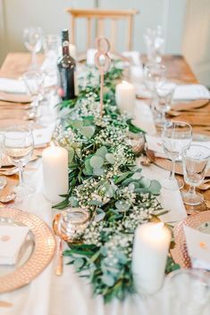 the table is set with candles, plates and napkins for an elegant dinner party