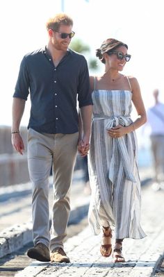 a man and woman walking down the street holding hands