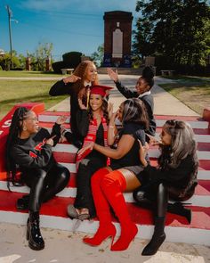 a group of young women sitting on top of a red and white striped bench next to each other