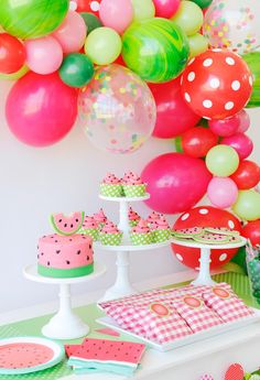 a table topped with lots of balloons and cake