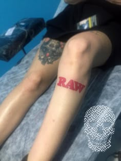 a person with tattoos on their legs sitting next to a swimming pool