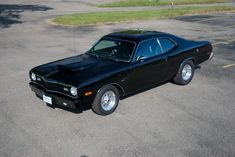 a black muscle car parked in a parking lot