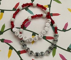 Let's Be Jolly with these handmade beaded stretch bracelets. Strung with ruby red colored glass seed beads and white glass balls these are Santa's suit on a bracelet! Choose from either clear confetti sprinkled black letter rounds or white and silver letter rounds. These are part of our Christmas collection and are to be worn alone or as part of a stack. Bracelets are available in a variety of lengths.  Pick your custom length from the drop down menu below.  All our bracelets are made with quali Seed Balls, Stack Bracelets, Holiday Beading, Santa Suits, Glass Balls, Jolly Holiday, Christmas Bracelet, Star Bracelet, Black Letter