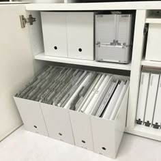 an organized file cabinet filled with files and folders in white, open to reveal the contents