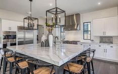 a large kitchen with an island in the middle and lots of stools around it