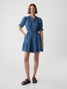 Soft crinkle gauze denim mini dress.  Ruffled crewneck.  Elbow puff sleeves.  Button front.  Braided tie belt at waist.  Tiered skirt.  * Fit: Relaxed.  An A-line silhouette that's easy through the chest with a flared opening.  Hits above the knee.  Model is approx.  5’10” wearing Denim Dress Outfit, Denim Ruffle Dress, Tiered Mini Dress, Womens Denim Dress, Estilo Denim, Denim Mini Dress, Gap Denim, Tier Skirt, Denim Mini