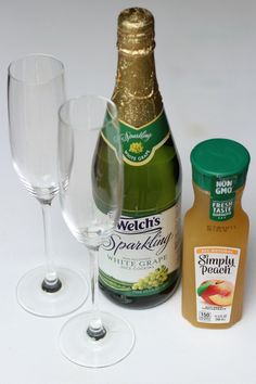 a bottle of wine and two glasses next to each other on a white table top