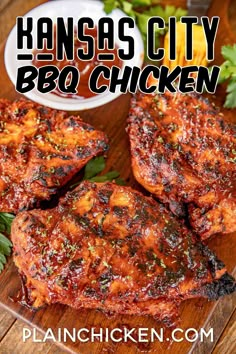 three pieces of bbq chicken sitting on top of a wooden cutting board