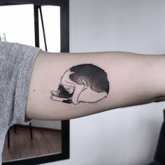 a black and white cat tattoo on the left inner arm, which is drawn in ink