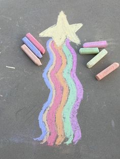 some crayons are laying on the ground next to a drawing of a star